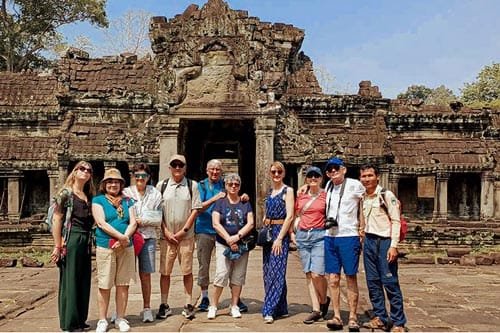 Groupe de voyageurs avec un guide devant le temple Preah Khan
